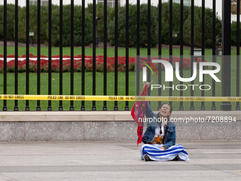 Climate activist Morning Star sits in front of the White House as she awaits arrest during a civil disobedience action against the continued...
