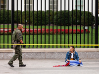 Climate activist Morning Star sits in front of the White House as she awaits arrest during a civil disobedience action against the continued...