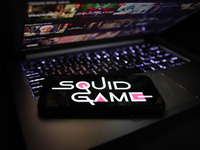 Squid Game series logo displayed on a phone screen and Netflix website displayed on a laptop screen are seen in this illustration photo take...