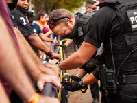 US Secret Service officers bolt barricades together in front of non-violent demonstrators during a Native American-led civil disobedience ac...