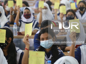 School students hold registration papers of vaccination at Colonel Malek Medical College Hospital to receive a dose of the Covid-19 coronavi...