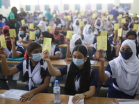 School students hold registration papers of vaccination at Colonel Malek Medical College Hospital to receive a dose of the Covid-19 coronavi...