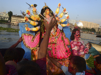 Hindu devotees immerse a clay idol of the Hindu Goddess Durga in the Buriganga River on the final day of the Durga Puja festival in Dhaka, B...