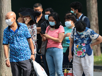 People wearing protective mask wait in queue to take their COVID-19 antigen rapid test outside a quick test centre on October 16, 2021 in Si...