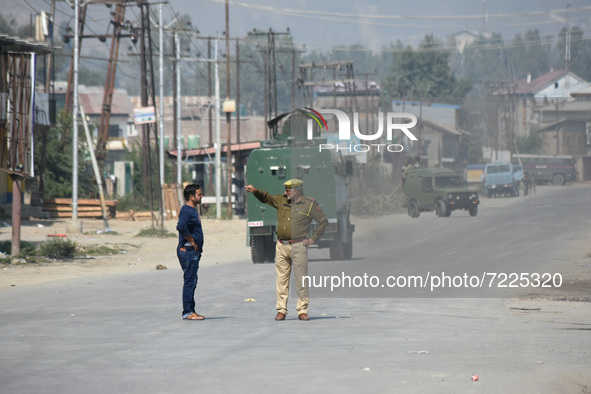 An Indian policeman stops a Kashmiri civilian during a gun battle between Indian Forces and militants in Pampore area of Pulwama district so...