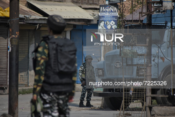 Indian paramilitary troopers stand alert on a deserted street during a gun battle between Indian Forces and militants in Pampore area of Pul...