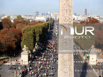 Runners compete on the Champs-Elysees avenue, at the foot of the Egyptian Obelisque of the Place de la Concorde and with the Arc de Triomphe...