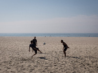 Three men are playing with a ball at Matosinhos beach on October 18, 2021, a city and a municipality in the northern Porto district of Portu...