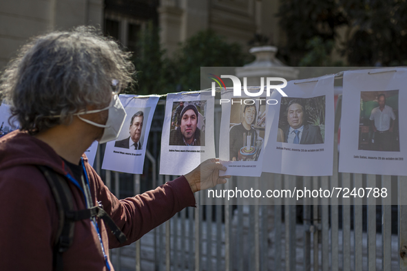 A person looks at the portraits of the fatal victims from the social uprising, which were placed just outside the former congress, where the...