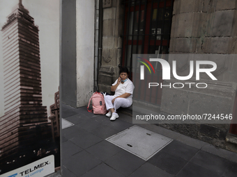 A nurse sits on Madero Street in Mexico City's Historic Centre during the COVID-19 emergency and the official return to the green epidemiolo...