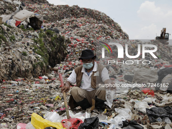 Chairman of the National Waste Coalition, Bagong Suyoto, show discarded infusion hoses which found at Burangkeng landfill in Bekasi regency,...