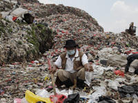 Chairman of the National Waste Coalition, Bagong Suyoto, show discarded infusion hoses which found at Burangkeng landfill in Bekasi regency,...