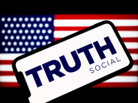TRUTH Social logo is seen displayed on a phone screen with Amercan flag displayed on a laptop screen in the background in this illustration...