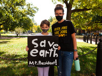 Mother and child attend a rally in support of 5 people on hunger strike at the White House for climate solutions and jobs. (