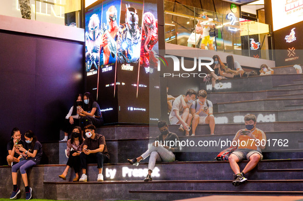 People rest in a seating area with seats marked out for safe distancing to prevent Covid-19 virus transmisson in a shopping mall in Singapor...