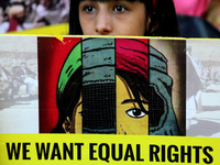 An Afghan national residing in India holds a placard as she participates in a protest demanding better rights for women in Afghanistan, duri...