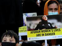 An Afghan national residing in India holds a placard as she participates in a protest demanding better rights for women in Afghanistan, duri...