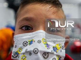 A child with his eyes in tears poses for a photo soon after receiving his first dose of COVID-19 vaccine as the Colombian government begins...