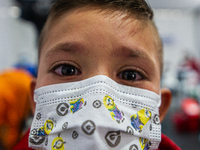 A child with his eyes in tears poses for a photo soon after receiving his first dose of COVID-19 vaccine as the Colombian government begins...