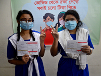 Bangladeshi school student shows the V sign after receiving a first dose of the Pfizer COVID-19 vaccine at the Ideal School and College cent...