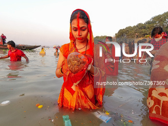 A lady is seen offering prayers to Sun god , during sunset time at a riverside in Kolkata , India , on 10 November 2021 , on the occasion of...