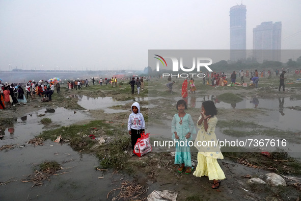 Children stand along the banks of the river Yamuna as Hindu devotees worship the Sun god on the occasion of Chhath Puja festival in New Delh...