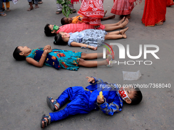 Devotees cross over children lying on the road during Chhata Puja festival. It is a ritual practiced for the well-being of children in Kolka...