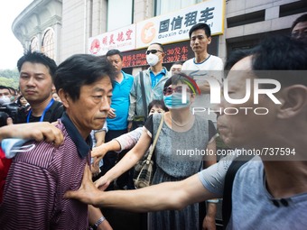 A government official being stopped by the angry residents while he tries to enter the hotel for the press conference.   - Hundreds of resid...