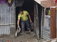 August 17, 2015, Kathmandu, Nepal --  A man cleans floodwater from his house in the slum area after the heavy overnight rainfall near the ba...