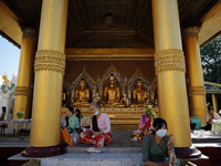 Buddhist devotees pray in front of Buddha statues during the full moon day of Tazaungmon, the eighth month of the Myanmar calendar, at Shwed...