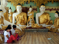 Buddhist devotees use their mobile phones in front of Buddha statues during the full moon day of Tazaungmon, the eighth month of the Myanmar...