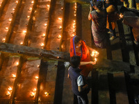 A lady prays with lighted earthen oil lamps at a river Ghat , on the occasion of Dev Deepavali in Kolkata , India , on 18 November 2021 .Dev...