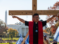 Immigration activist Jose Landaverde hangs on a wooden cross during a direct action by the National TPS Alliance at the White House.  Activi...