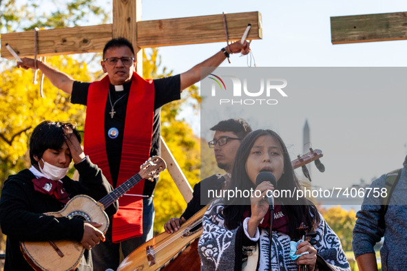 Immigration activist Father Jose Landaverde hangs on a wooden cross during a direct action by the National TPS Alliance at the White House....
