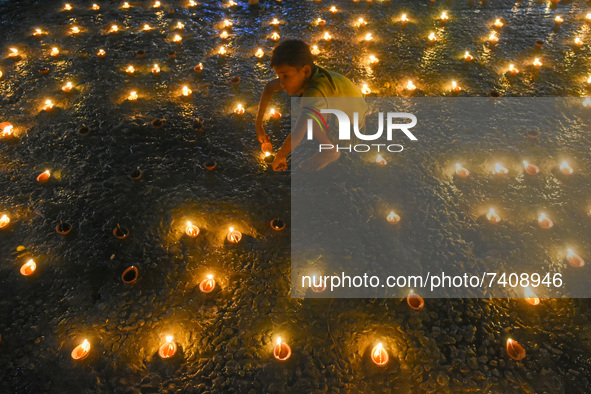 A little kid is seen lighting oil lamps at a river ghat on the occasion of Dev Deepavali in Kolkata , India , on 19 November 2021 .Dev Deepa...