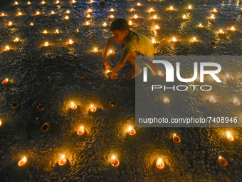 A little kid is seen lighting oil lamps at a river ghat on the occasion of Dev Deepavali in Kolkata , India , on 19 November 2021 .Dev Deepa...