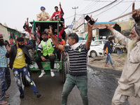Farmers celebrate at a protest site after Prime Minister Narendra Modi announced that he will repeal the controversial farm laws, at Singhu...