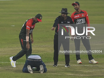 A supporter of Bangladesh kneels down in front of an empire and Bangldesh's cricketers after he run into the cricket pitch during the second...
