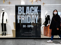 Shoppers walk past Black Friday advertisement banner in Galeria Krakowska shopping mall in Krakow, Poland on November 24, 2021 (