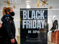 Shoppers walk past Black Friday advertisement banner in Galeria Krakowska shopping mall in Krakow, Poland on November 24, 2021 (