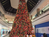 People take a photo by a large Christmas tree at a shopping mall the day before Black Friday in Toronto, Ontario, Canada, on November 25, 20...