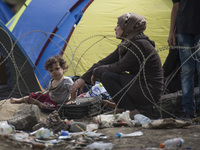 A migrant woman and her child wait on the Macedonian-Greek border where she and other migrants are being held, since Macedonia declared emer...