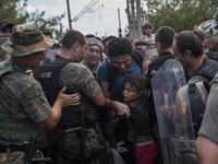 A young migrant girl faints after waiting on the Macedonian-Greek border where migrants are being held, since Macedonia declared emergency a...