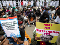 Banners against West Papua becoming part of Indonesia. A number of Papuan students demonstrate at the horse statue, Jakarta, Indonesia  amid...