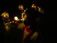 Healthcare workers and activists hold electric candles during a vigil to mark World Aids Day in Jakarta, 1 December 2021. World AIDS Day is...