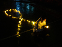 Activist hold electric candles during a vigil to mark World Aids Day in Jakarta, 1 December 2021. World AIDS Day is marked worldwide annuall...