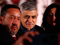 Mayor of London Sadiq Khan poses for a selfie with guests following the ceremony for the switching-on of the Christmas tree lights in Trafal...