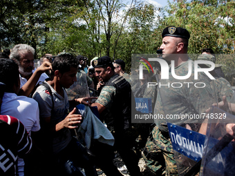 Refugees scramble with the Macedonian border police on the Greek-Macedonian border. Gevgelja, August 24, 2015. (Photo by Kostis Ntantamis/Nu...