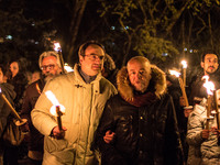 People participate in a candle rally in L'Aquila on April 6, 2014 to commemorate the fifth anniversary of the major earthquake which struck...
