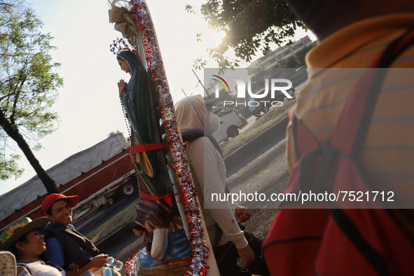 A faithful  holds an image of Virgin Of Guadalupe in their back while walks along Ignacio Zaragoza Avenue to arrive the Basilica of Guadalup...